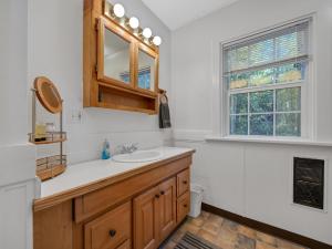 a bathroom with a sink and a mirror and a window at Rockin Rhody Retreat in Rhododendron +49 photos