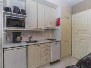 a kitchen with white cabinets and a sink at Holiday Home Levin mini by Interhome in Sirkka