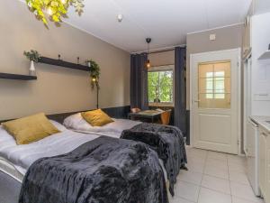 two beds sitting in a room with a kitchen at Holiday Home Levin mini by Interhome in Sirkka