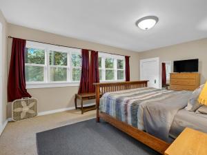 a bedroom with a bed and a tv and windows at Rockin Rhody Retreat in Rhododendron