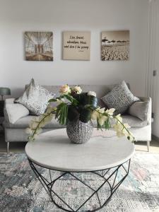 a living room with a table with a vase of flowers at Sunset Cliffs Luxury Apartment Benidorm in Benidorm