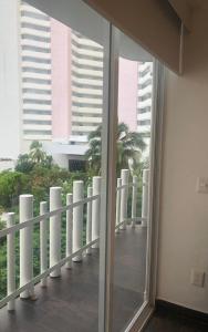a balcony with a view of palm trees and buildings at SKY INN Oficial Acapulco Suites & Condo Mediterrane in Acapulco