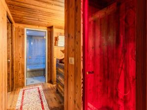a room with a red wall in a wooden house at Chalet Maset Pozzati by Interhome in Bresimo