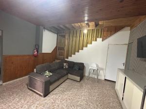 a living room with a couch and a staircase at Ti caze Montplaisir 2 in Saint-Louis