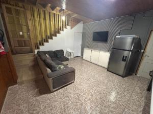 a living room with a couch and a refrigerator at Ti caze Montplaisir 2 in Saint-Louis