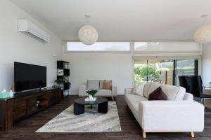 a living room with a white couch and a tv at Modern Newnham Retreat in Newnham