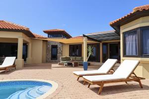 a patio with two lounge chairs and a pool at Casa Tranquilidad in Willemstad +62 photos