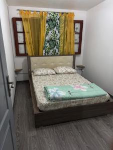 a bedroom with a bunk bed with yellow curtains at Ti caze Montplaisir 2 in Saint-Louis +2 photos