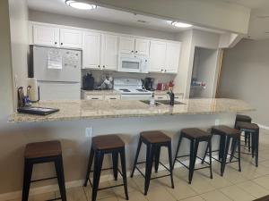 a kitchen with a counter with four bar stools at Lake Ozarks Get Away in Lake Ozark