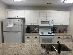 a kitchen with white appliances and white cabinets at Lake Ozarks Get Away in Lake Ozark