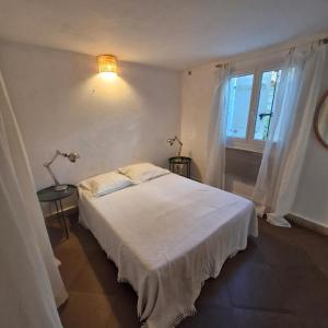 a bedroom with a white bed and a window at Casa Francesca in Saint-Florent
