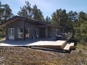 a small house with a deck in front of it at Holiday Home Västantill by Interhome in Hitis +60 photos
