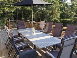 a table and chairs on a deck with an umbrella at Holiday Home Västantill by Interhome in Hitis