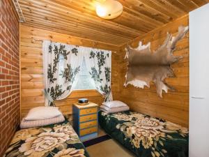 a room with two beds and a window in a cabin at Holiday Home Metsämökki by Interhome in Barkarböle