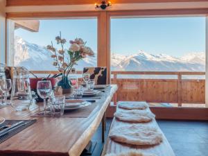a dining table with glasses and a view of mountains at Chalet Chalet Flocon de Neige by Interhome in Nendaz
