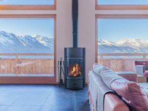 a fireplace in a living room with a view of mountains at Chalet Chalet Flocon de Neige by Interhome in Nendaz
