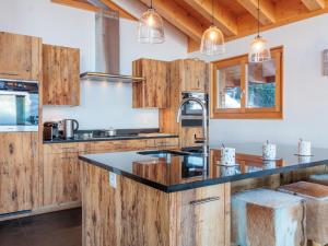 a kitchen with wooden cabinets and a black counter top at Chalet Chalet Flocon de Neige by Interhome in Nendaz