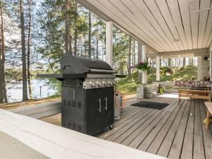 a outdoor grill on a deck with a table at Holiday Home Kivilöytö by Interhome in Mouhu +14 photos