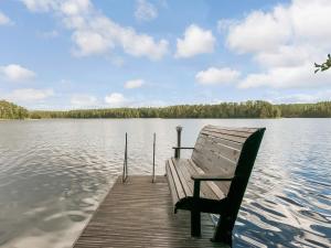 a bench sitting on a dock on a lake at Holiday Home Kivilöytö by Interhome in Mouhu