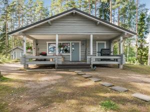 a small house with a porch and a picnic table at Holiday Home Kivilöytö by Interhome in Mouhu