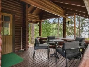 a porch of a log cabin with a table and chairs at Holiday Home Salmela by Interhome in Ollila +14 photos
