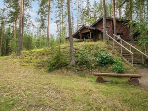 a log cabin in the woods with a bench at Holiday Home Salmela by Interhome in Ollila