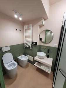 un bagno con WC, lavandino e specchio di Hotel Elimo a Erice Altre 100 foto