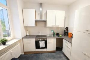 a kitchen with white cabinets and a sink at Ferienwohnung Zentralglück in Meerane +16 photos