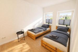 two beds in a room with two windows at Ferienwohnung Zentralglück in Meerane