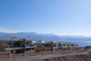 a row of houses on a hill next to the water at וילה פאן 4 חדרי שינה בריכה מחוממת Villa Fun 4 BR Heated Pool in Eilat