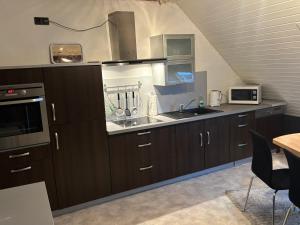 a kitchen with brown cabinets and a sink at Ferienwohnung Moselherz in Monzelfeld