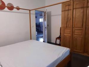 a bedroom with a bed and a wooden cabinet at Villa AfricaSolly in Poponguine