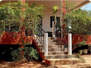a staircase in front of a house with trees at Villa AfricaSolly in Poponguine