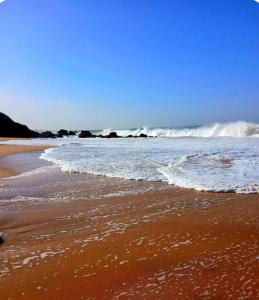 a sandy beach with waves in the ocean at Villa AfricaSolly in Poponguine
