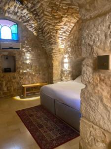 a bedroom with a bed in a stone wall at לאה- וילה בוטנית LEAH- botanical villa in Safed