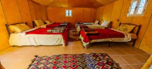 a room with three beds and a couch in it at Mustapha Camp Merzouga in Merzouga +83 photos