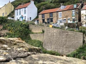 a group of houses on the side of a hill at Old Jack's Cottage, Staithes in Staithes