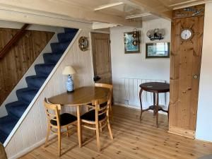 a dining room with a table and a staircase at Old Jack's Cottage, Staithes in Staithes