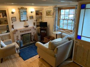 a living room with two couches and a fireplace at Old Jack's Cottage, Staithes in Staithes
