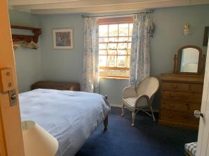 a bedroom with a bed and a window and a dresser at Old Jack's Cottage, Staithes in Staithes