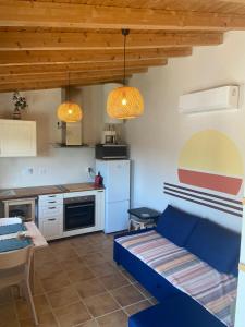 a living room with a blue couch and a kitchen at Coastal Vineyard Hideaway in Torres Vedras