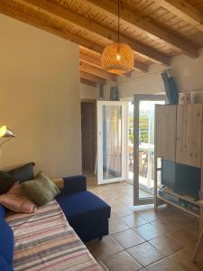 a living room with a blue couch and a television at Coastal Vineyard Hideaway in Torres Vedras
