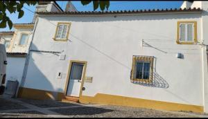 a white building with two windows and a door at Alentejo Colours Avis in Avis