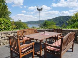 a wooden table and chairs with a view of the water at Ferienhaus am Rursee - Haus Eiche in Simmerath