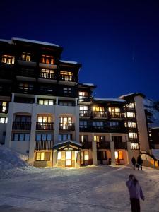 a large building in the snow at night at L ADRET - Duplex 6 pers 2 chambres - Belle Plagne PARADISKI in La Plagne Tarentaise