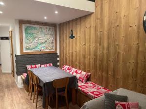 a dining room with a table and chairs and wooden walls at L ADRET - Duplex 6 pers 2 chambres - Belle Plagne PARADISKI in La Plagne Tarentaise