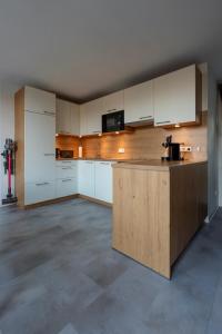 an empty kitchen with white cabinets and a counter at Das Chalet in Himmelkron