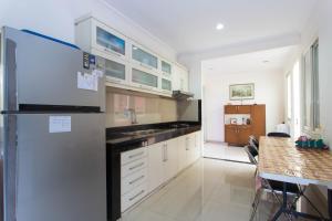 a kitchen with a refrigerator and a table in it at RedDoorz Plus near Siloam Karawaci in Tangerang