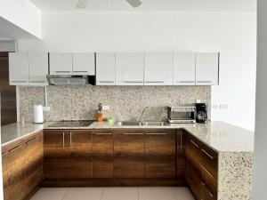 a kitchen with wooden cabinets and a sink at Departamento frente al mar - Resort Playa Azul in Tonsupa