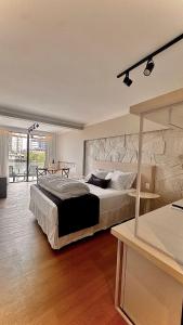 a bedroom with a large bed and a stone wall at Azurine Pousada in Passo de Torres +92 photos